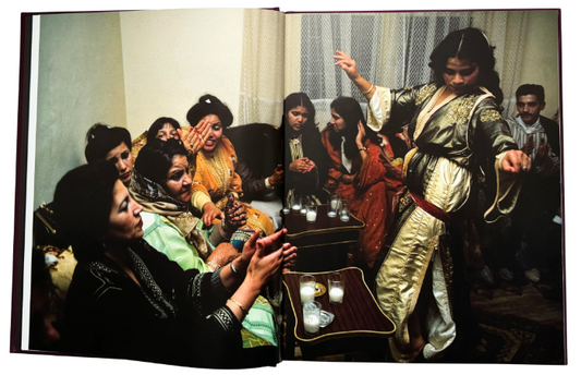 spread with one colour photo of a group of people on the sofa with one woman dancing