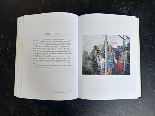 Spread with text on the left page and one colour photo on the right of people behind a wired fench.