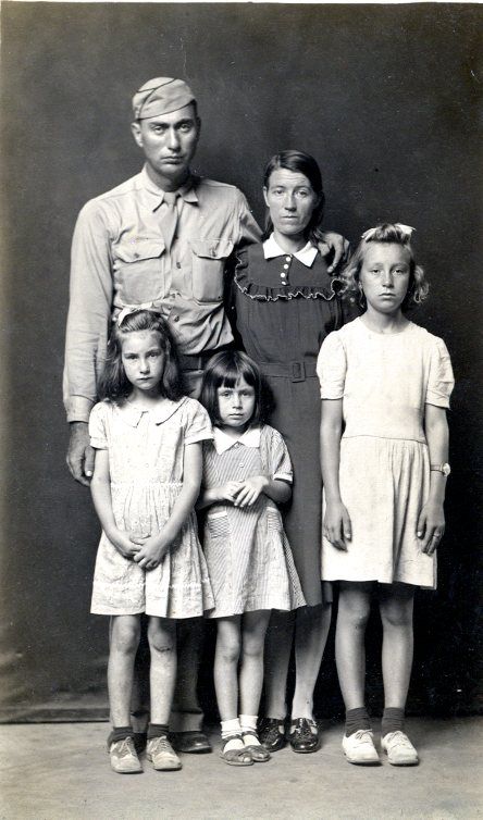 black and white photo of a family of 5 in front of a black backdrop
