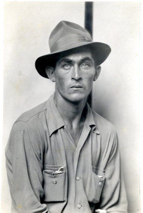 black and white portrait of a man wearing a hat in front of a white background