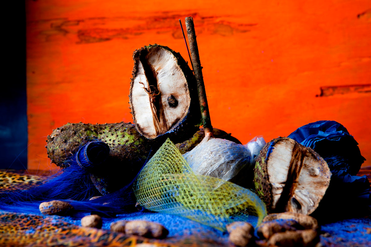 Red background with on a table some fruits and a blue and green net.