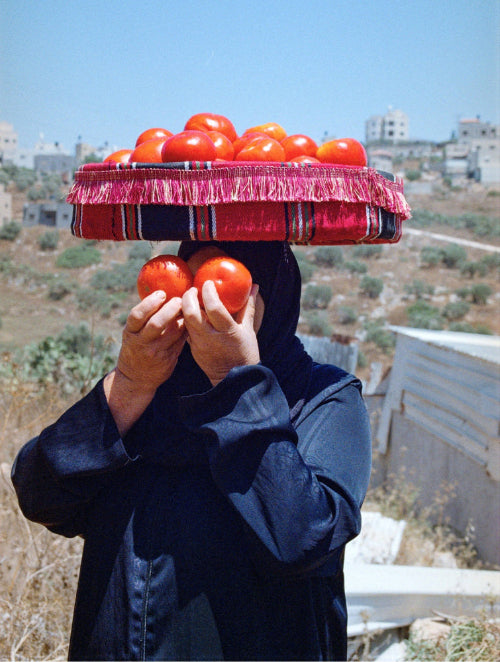 vrouw in Palestina met tomaten op hoofd en voor ogen