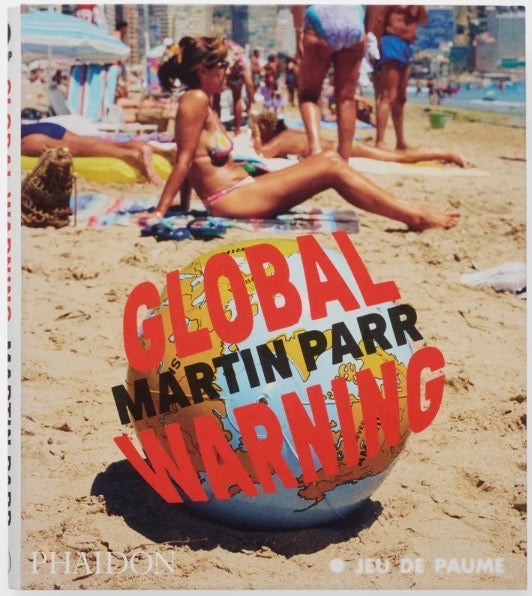 Colour cover with Parr image of people sunbathing on a beach, with an inflatable globe. On it the title in red letters and the name Martin Parr in black letters.