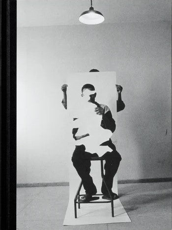 man on chair holding a cutout of himself