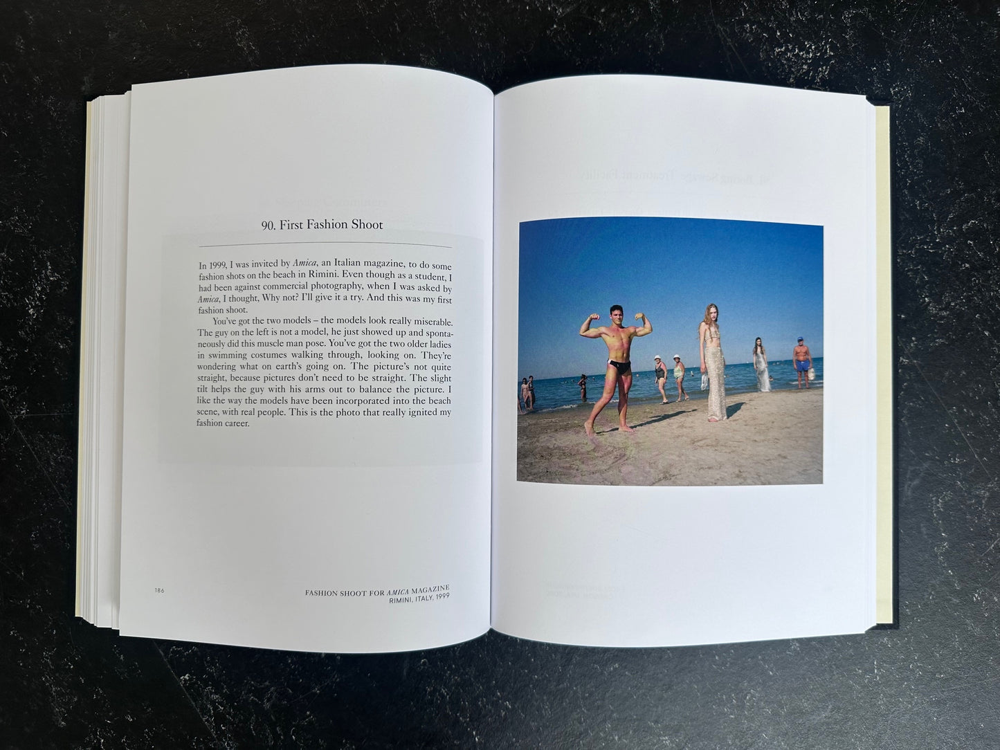 Spread with text on the left page and one colour photo on the right of people standing on a beach