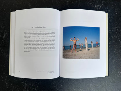 Spread with text on the left page and one colour photo on the right of people standing on a beach