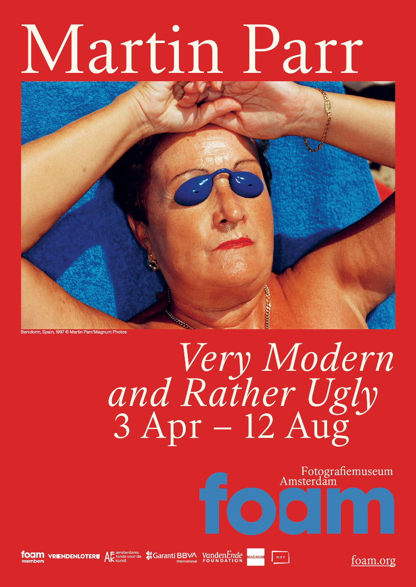 Red poster with white letters and a horizontal image of a woman tanning, wearing small blue plastic sunglasses to protect her eyes. 