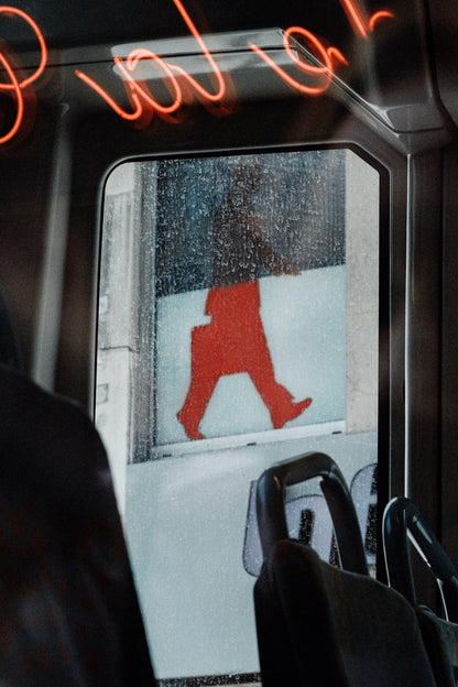 street view from a bus, showing red letters and a red silhouette of a man
