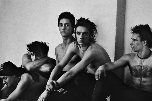 Black and white image of five shirtless individuals sitting together