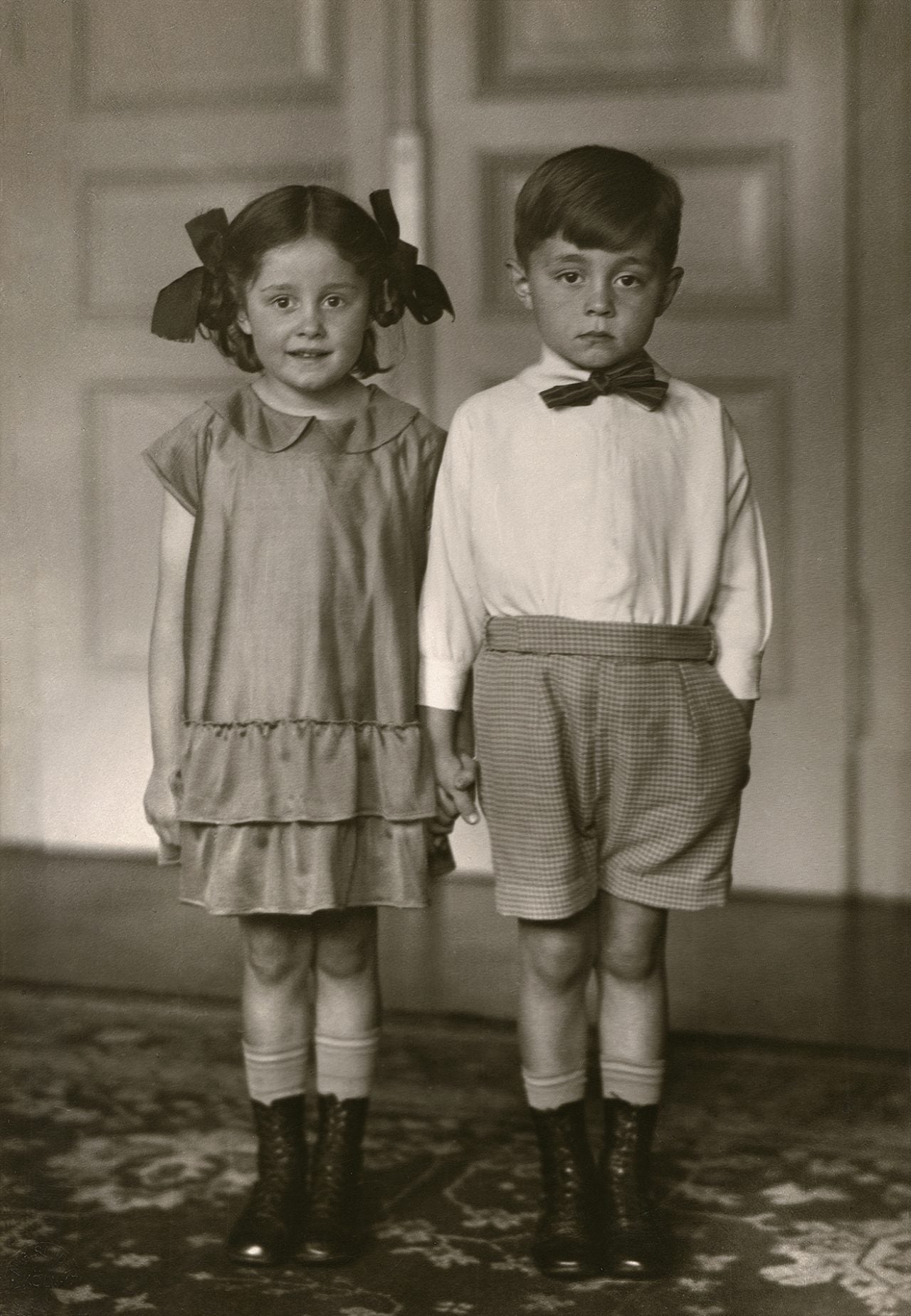 black and white portrait of little boy and girl holding hands