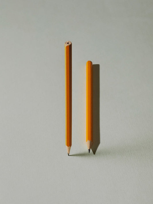 Two yellow pencils on grey background