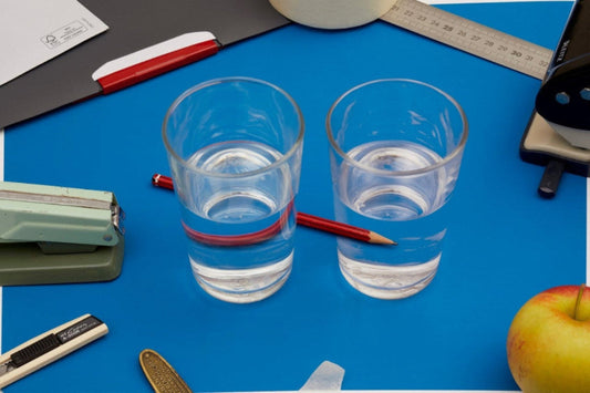 desk with two glasses of water and red pencil