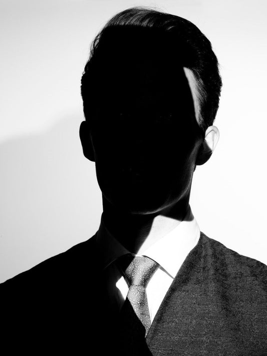 black and white portrait of man with face in shadow