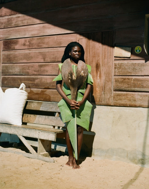 Surinam woman with green leaf as a dress holding a dried up leaf