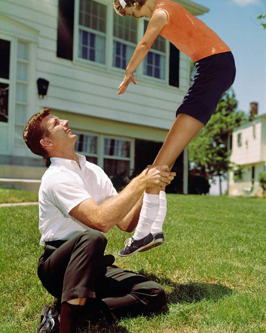 man and child playing in the grass