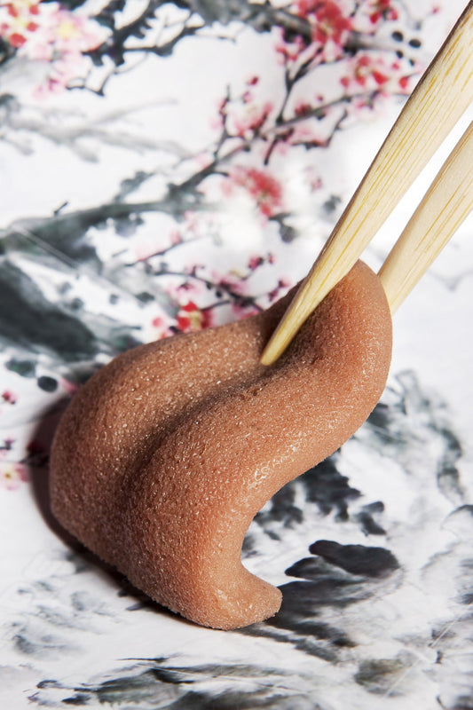 Chopsticks holding up a tongue on a floral background