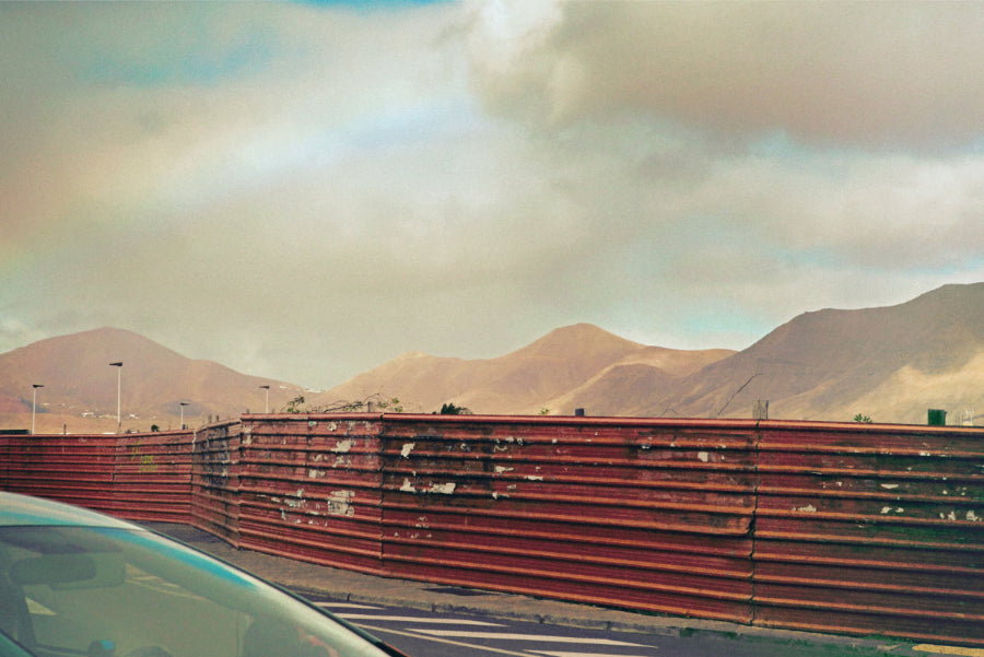 car and metal fence facing mountains