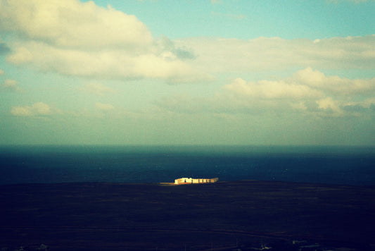 sun on white house in dark valley