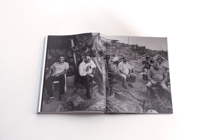spread foam magazine the test of time showing a black and white image by sakir khader showing a group of mean sitting outside in debres
