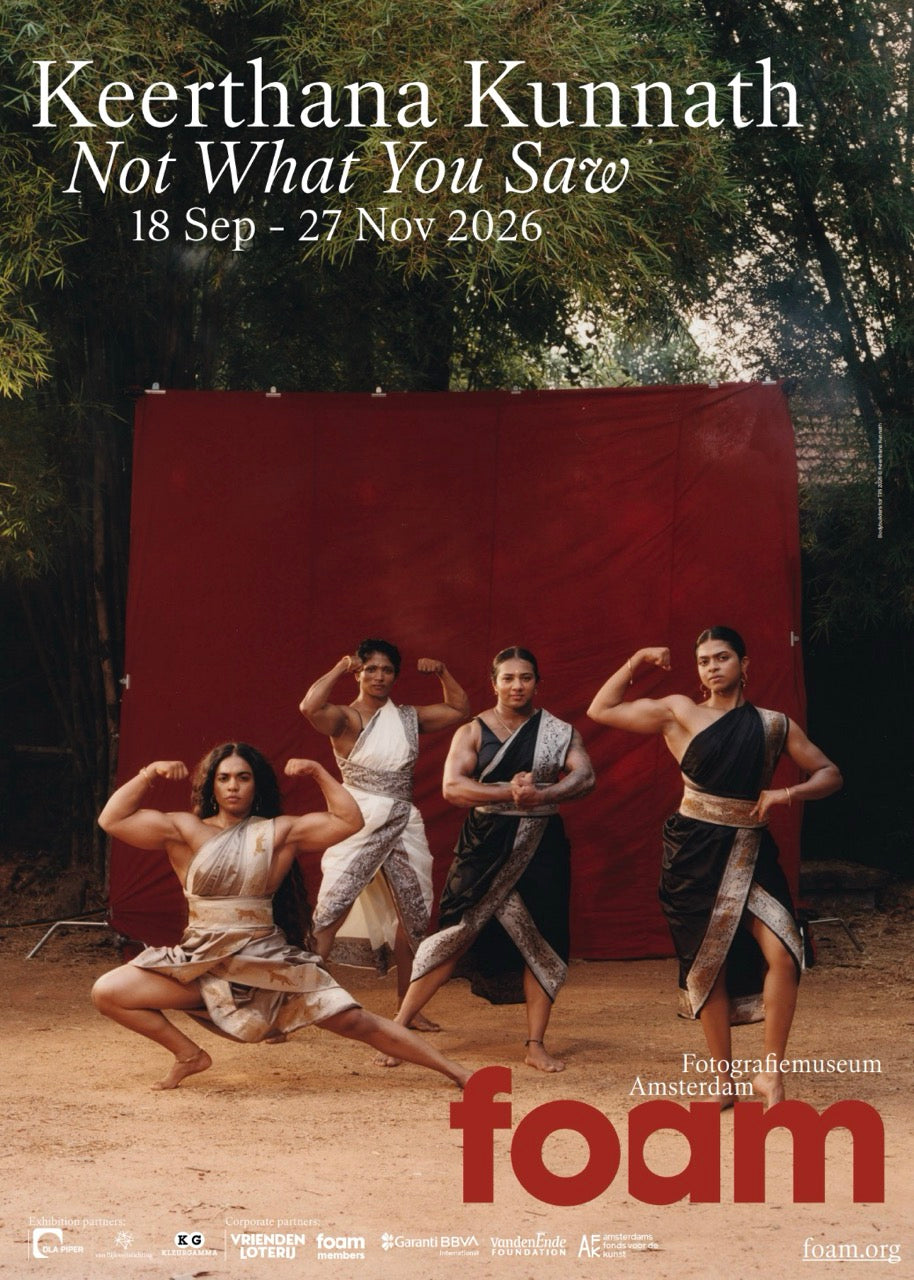 Standing exhibition poster with colour image of a group of four female bodybuilders dressed in formal and festive dresses, standing outside in front of a red textile backdrop and a group of large trees.
