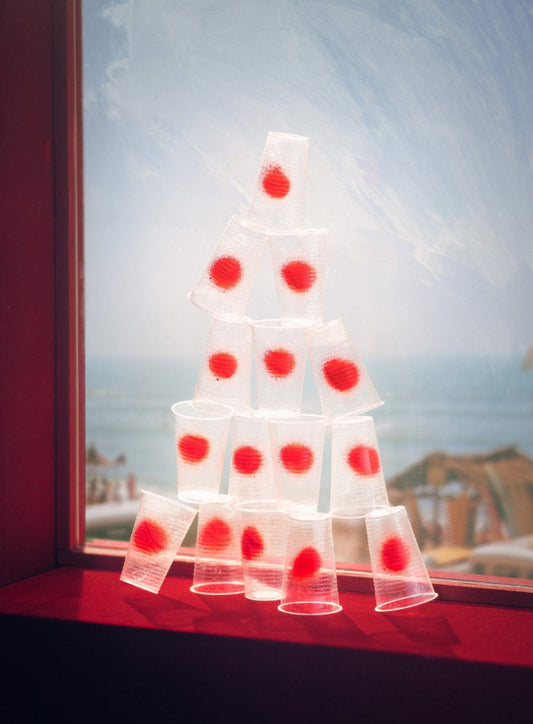 pile of plastic cups with spray painted red dots