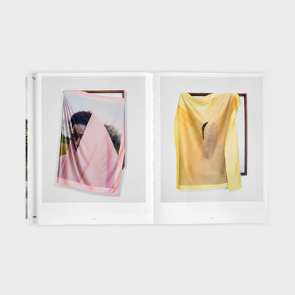 spread of the book showing a pink and yellow cloth with print of Tyler's work