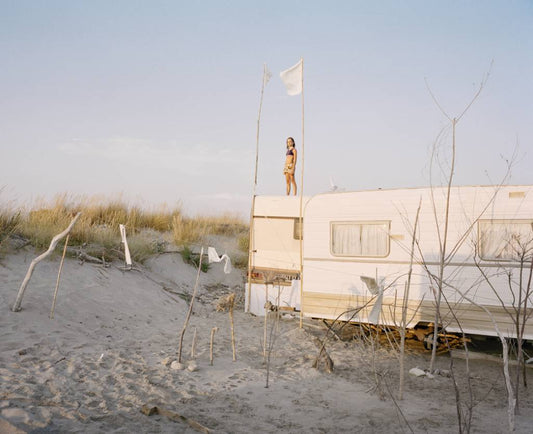 a camper on the beach with a person on top